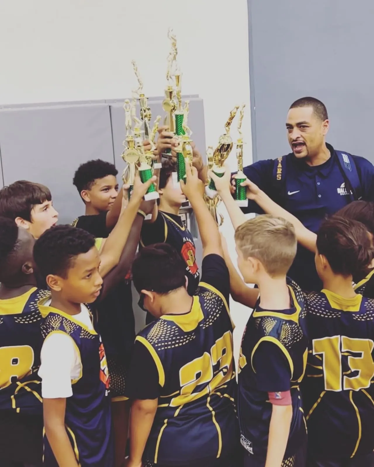 Younger Ballstars players cheering together with their coach